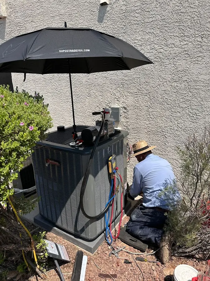 HVAC technician performing outdoor AC maintenance in Pantops